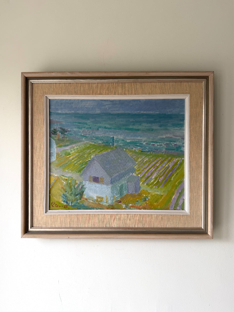 Framed vintage oil painting of a coastal scene with a cottage. Available at Hue.