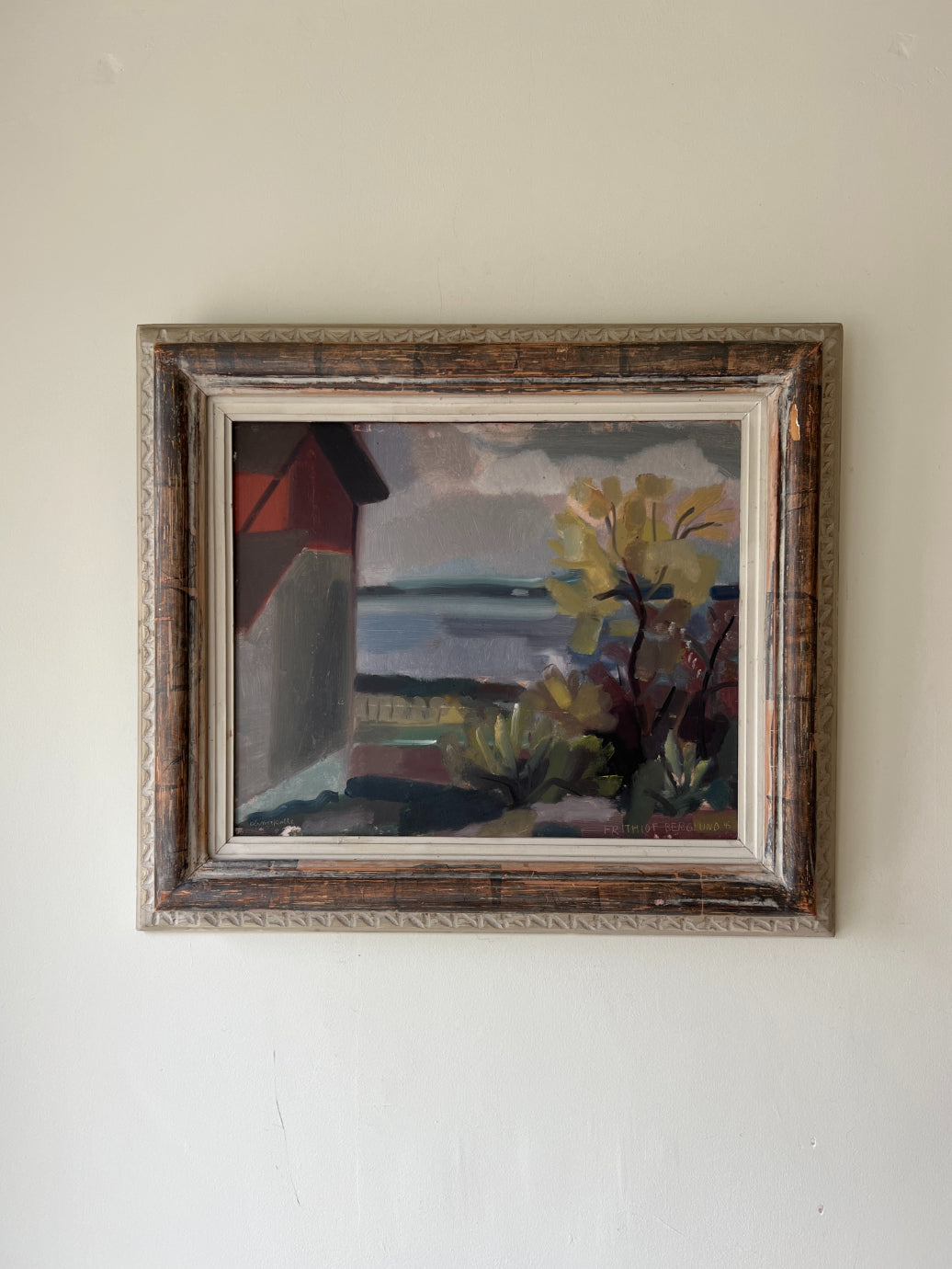Framed vintage oil painting of a red house on the shores of a lake. Available at Hue.