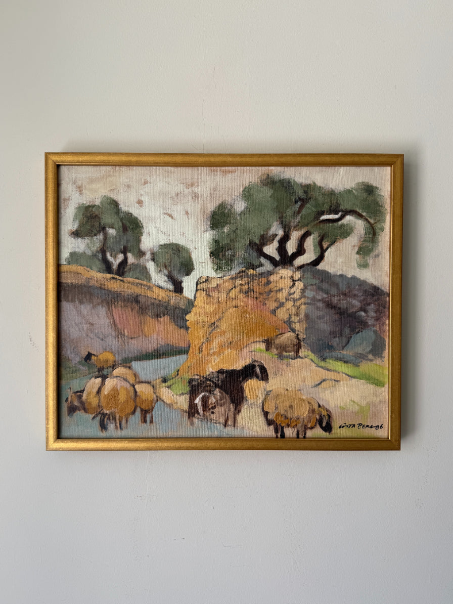 A framed vintage landscape painting depicting sheep and goats grazing near a stone wall and trees. Available at Hue. 