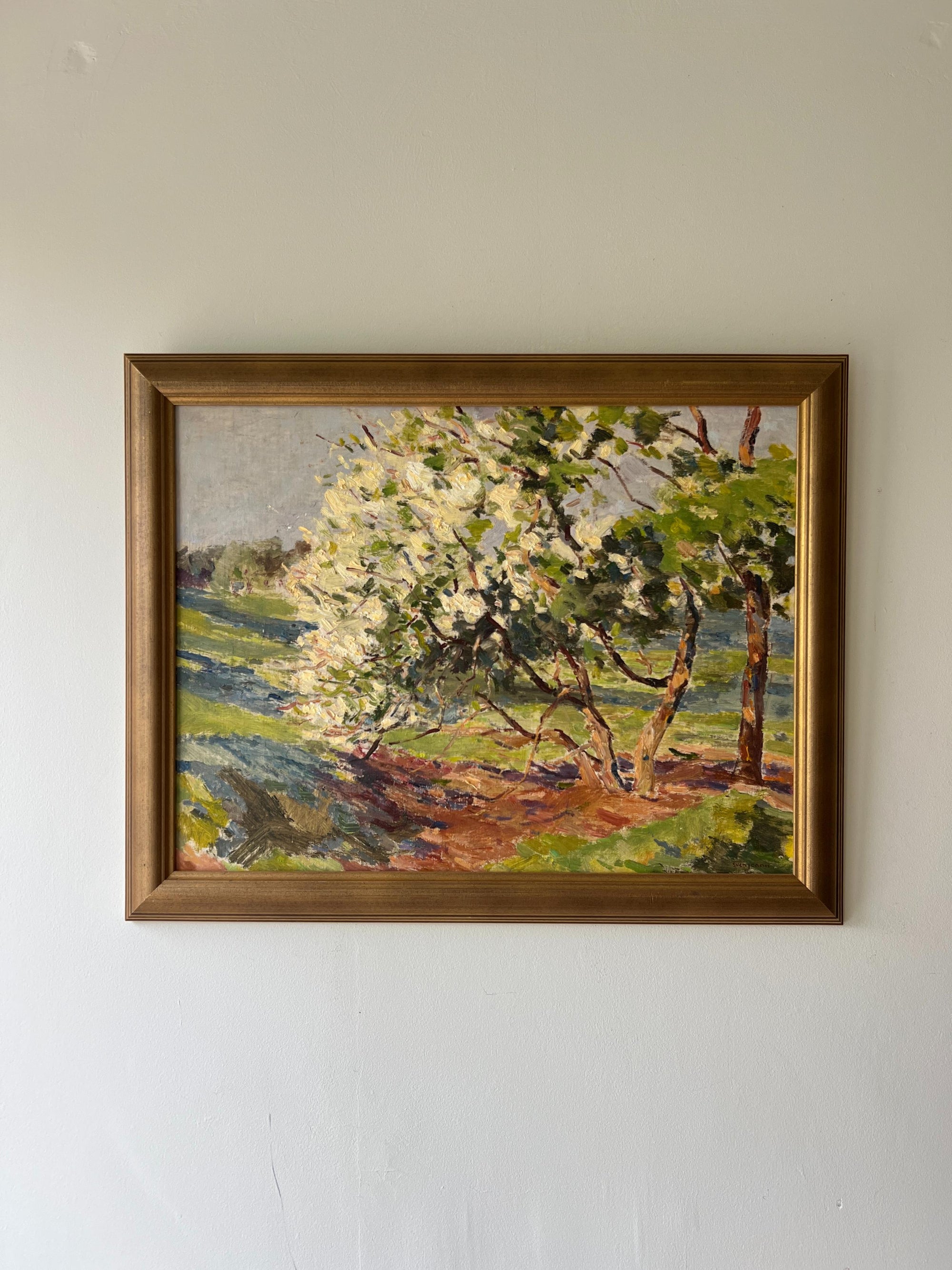 Framed vintage oil painting of a landscape with a tree in blossom, available at Hue.