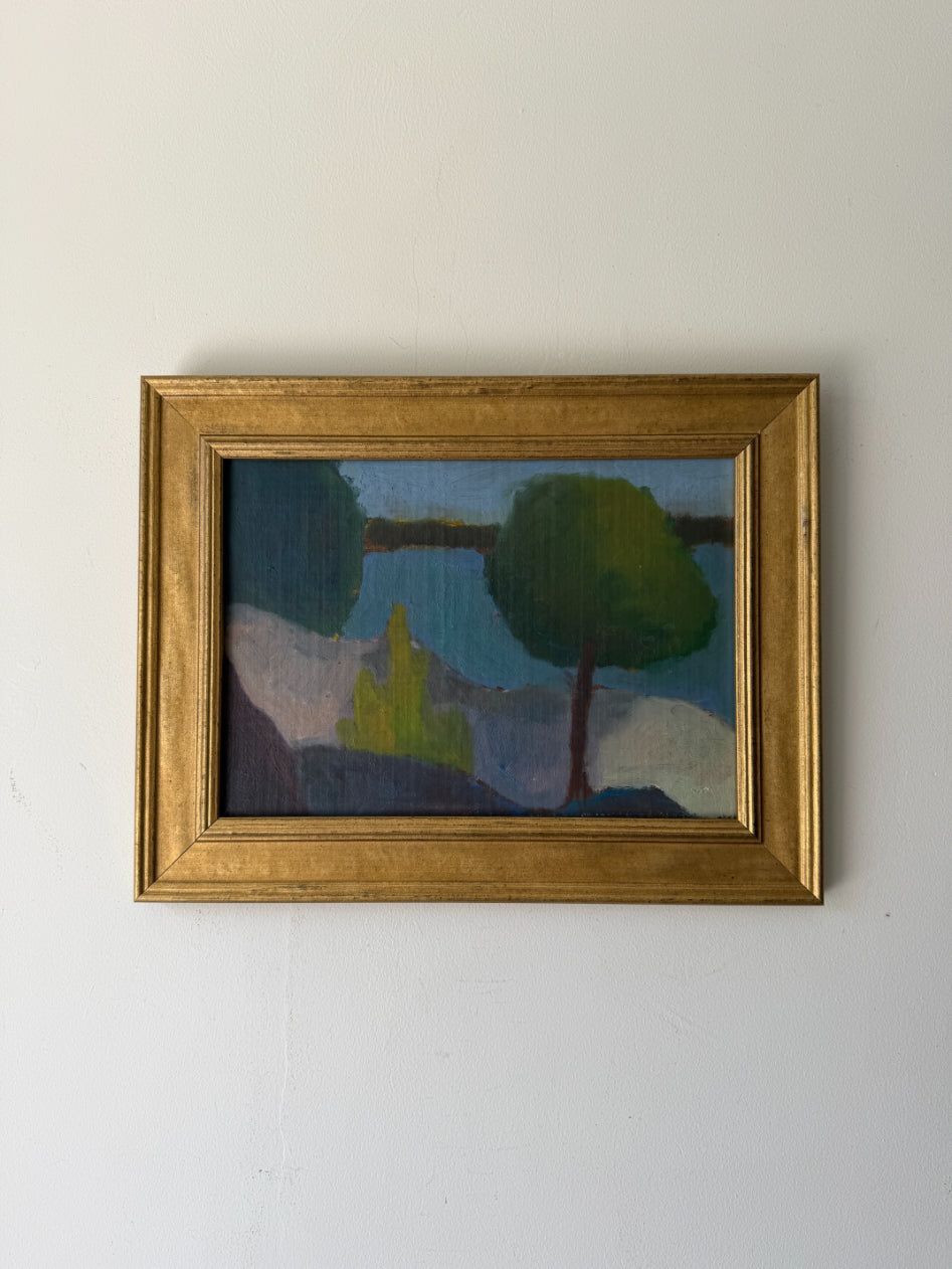A framed vintage landscape oil painting featuring green trees and a body of water. Modernist in style. Available at Hue. 