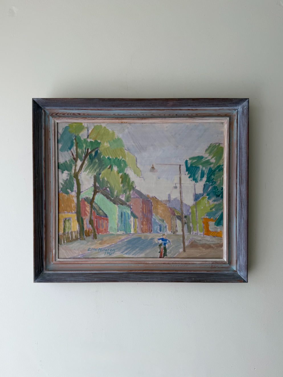 Framed vintage oil painting of a street scene with trees and buildings and a boy on a bicyle. Available at Hue. 
