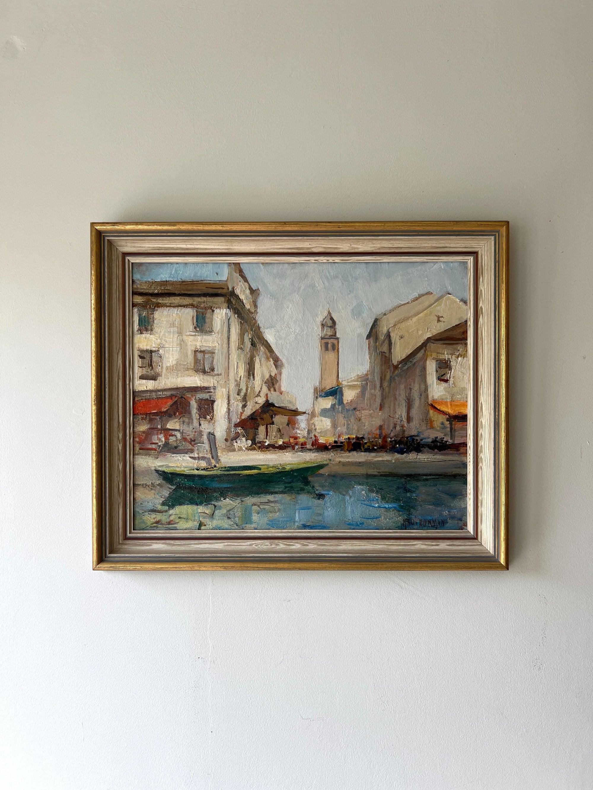 A framed vintage oil painting of a Venetian canal scene. Available at Hue. 