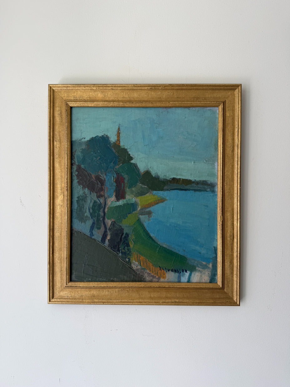 A framed vintage landscape oil painting featuring blue water, green hills, and dark trees. Available at Hue. 