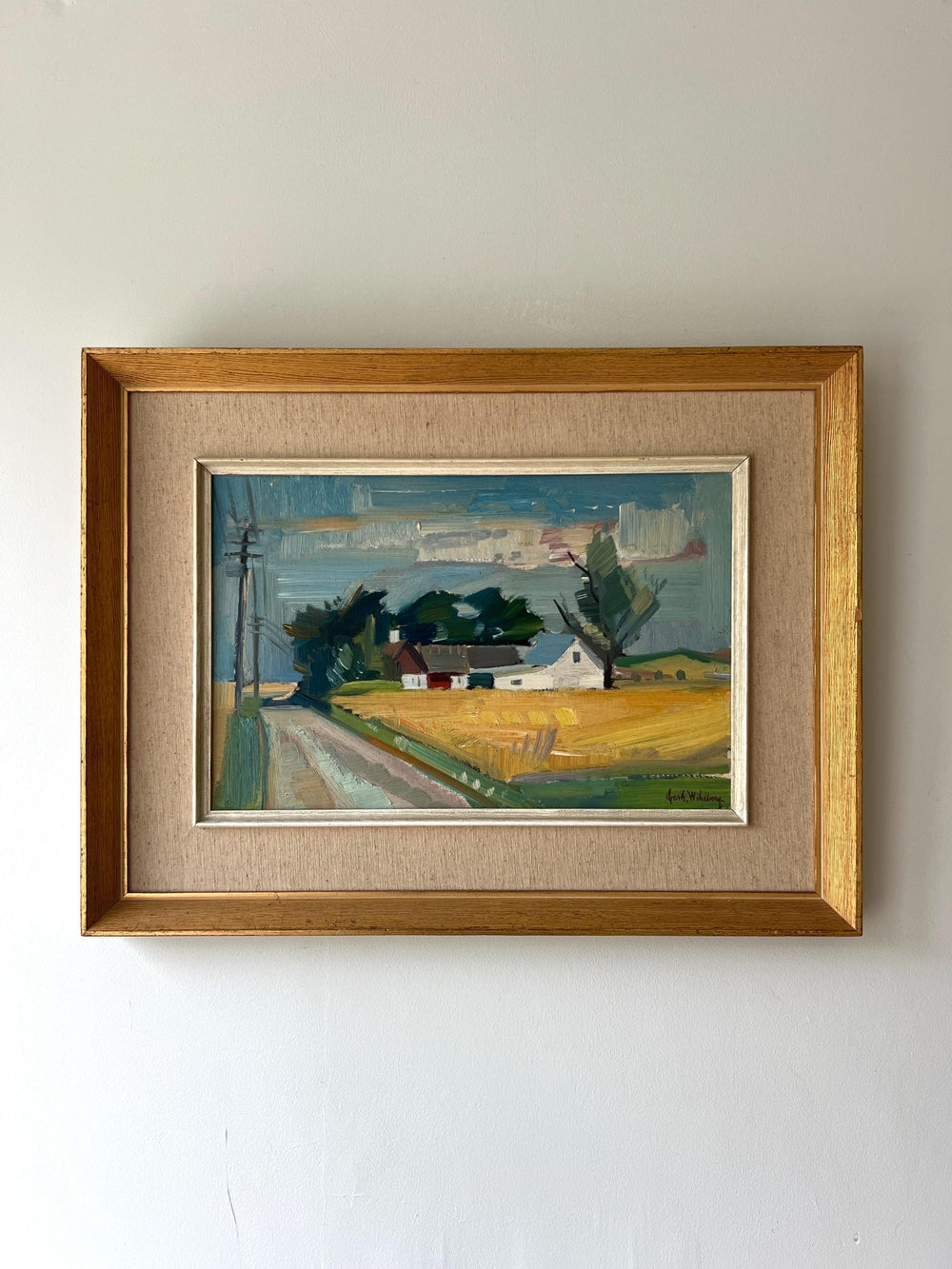 Framed vintage oil painting of a rural landscape with a house and yellow fields in a gilt frame with linen mount, available at Hue.