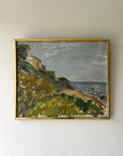 Framed vintage oil painting of a coastal landscape with greenery and water in a slim gilt frame, available at Hue.