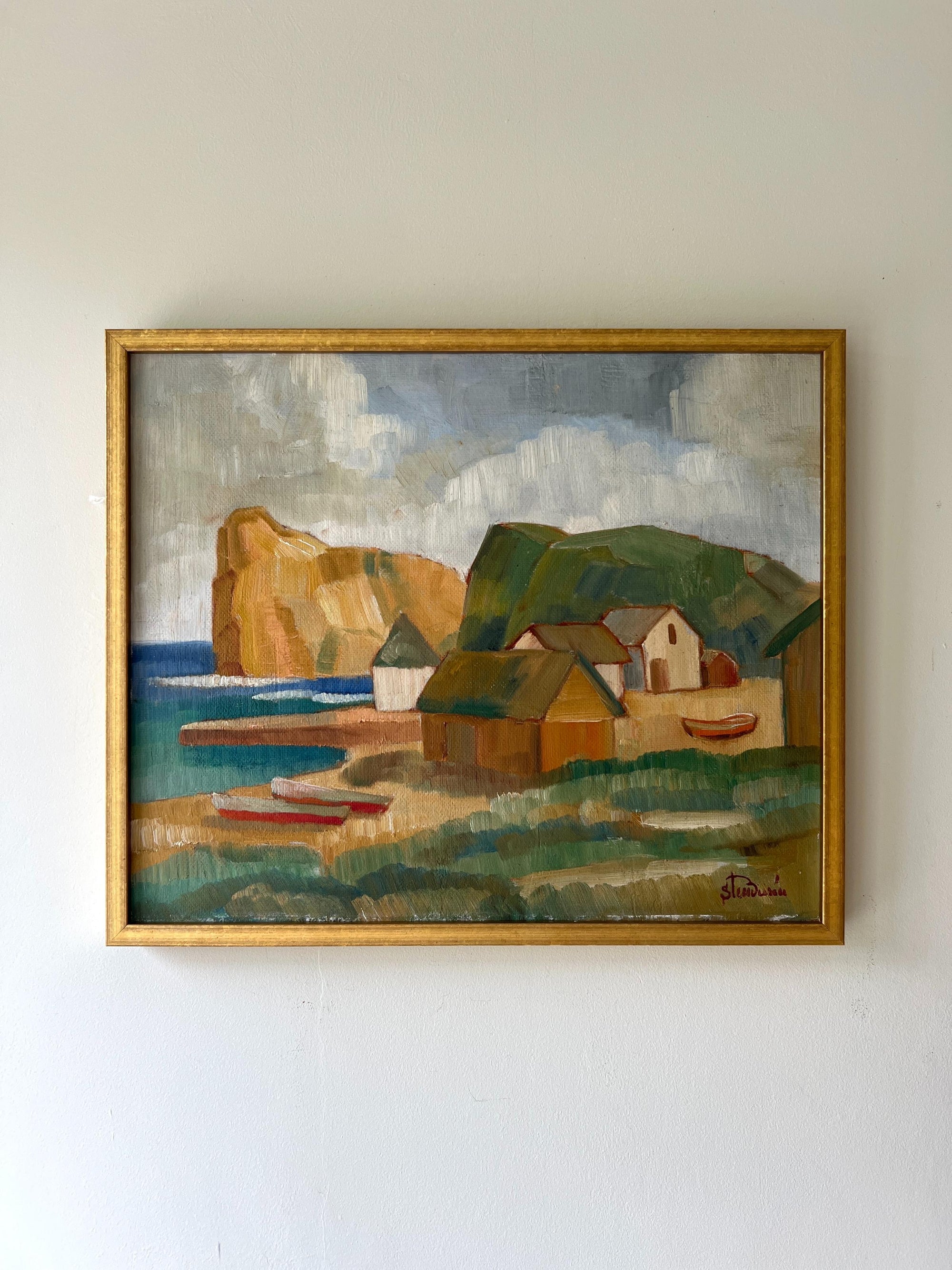 Framed vintage oil painting of a coastal scene with houses and boats in a gilt frame, available at Hue.