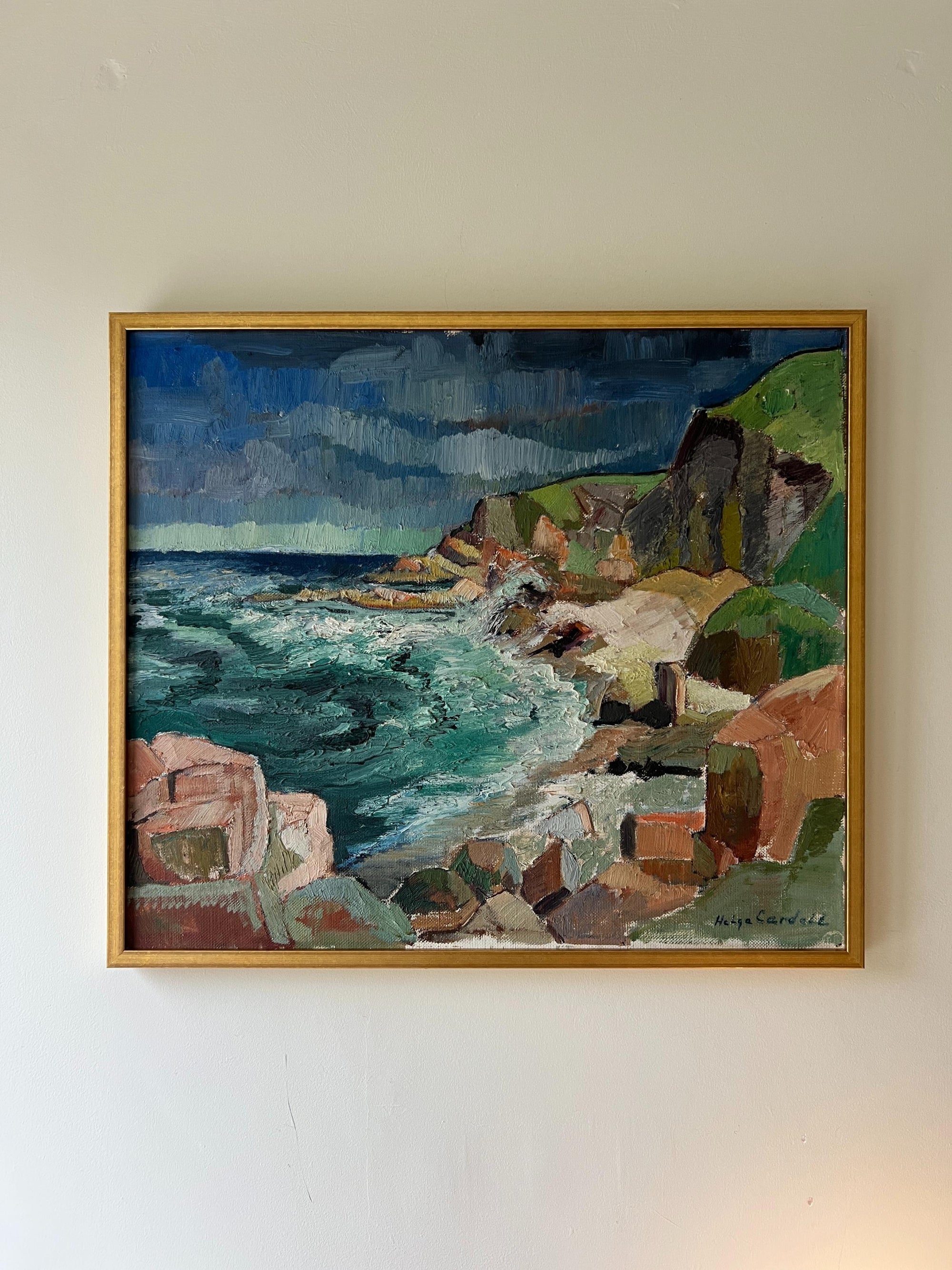 A framed vintage oil painting of a coastal scene with waves and cliffs. Available at Hue. 