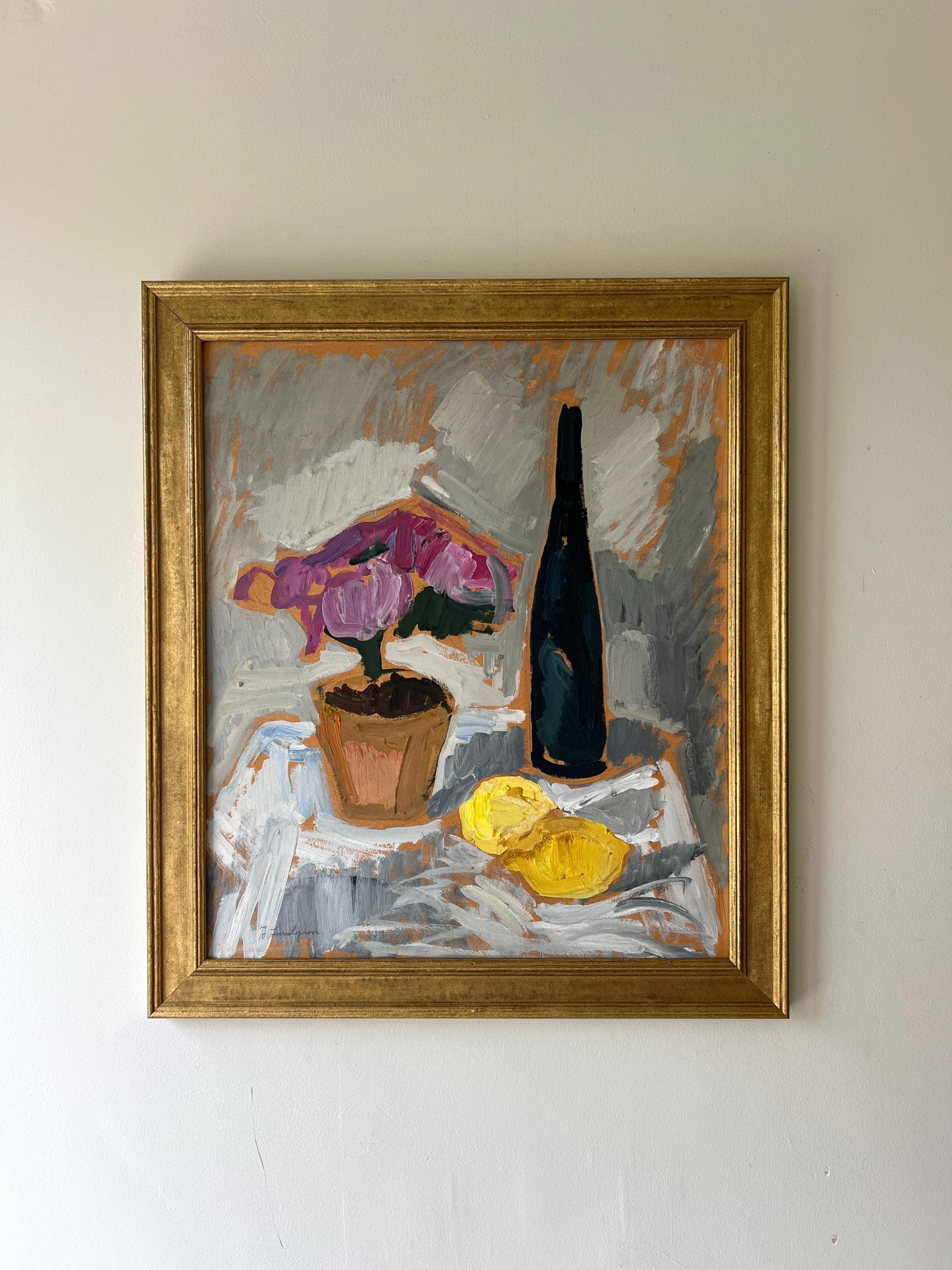 Framed vintage still life painting with a bottle, potted pink roses, and lemons on a table, available at Hue.