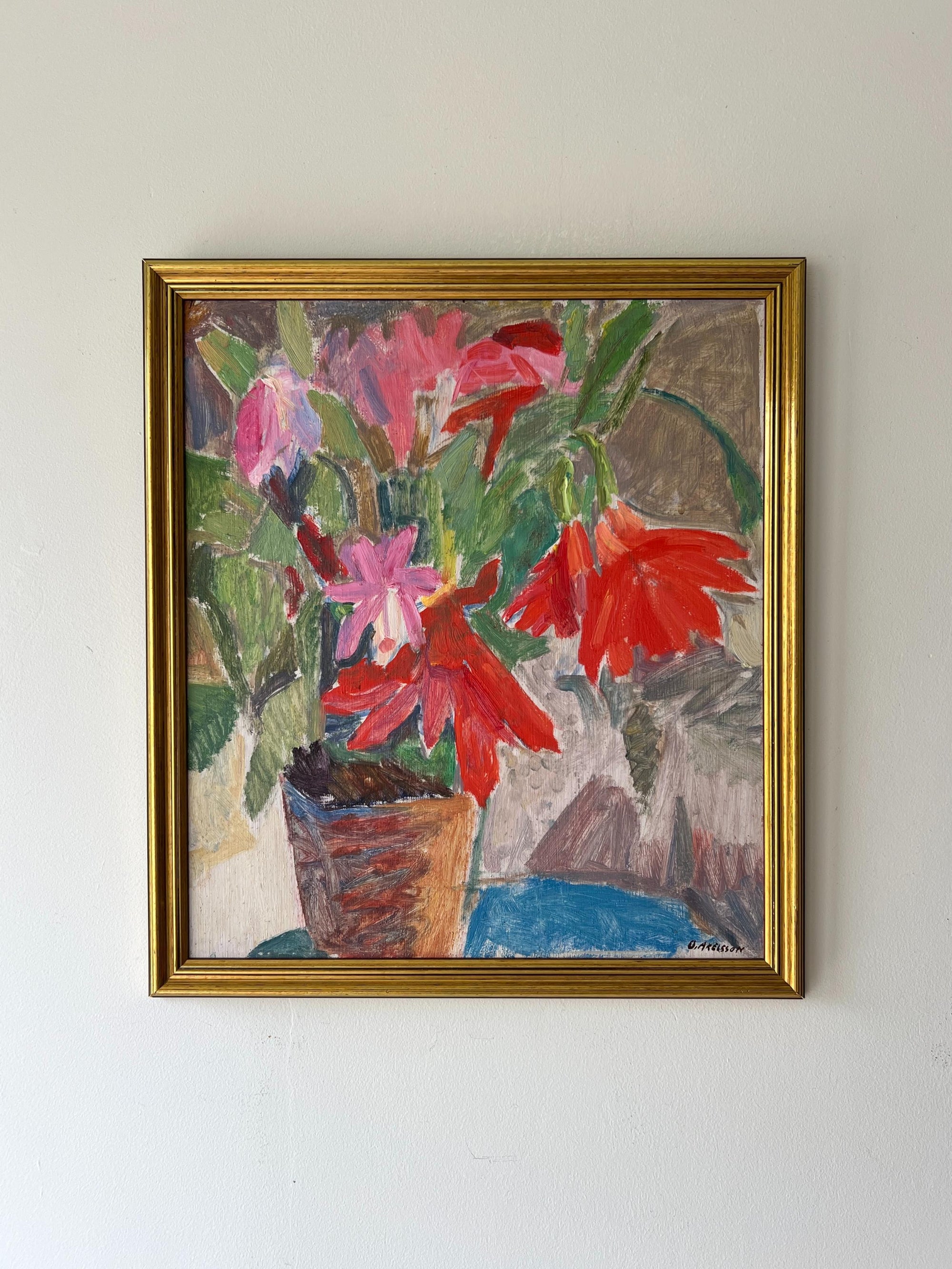 A framed vintage oil painting of a sill life bouquet of red flowers in a terracotta pot. Available at Hue. 