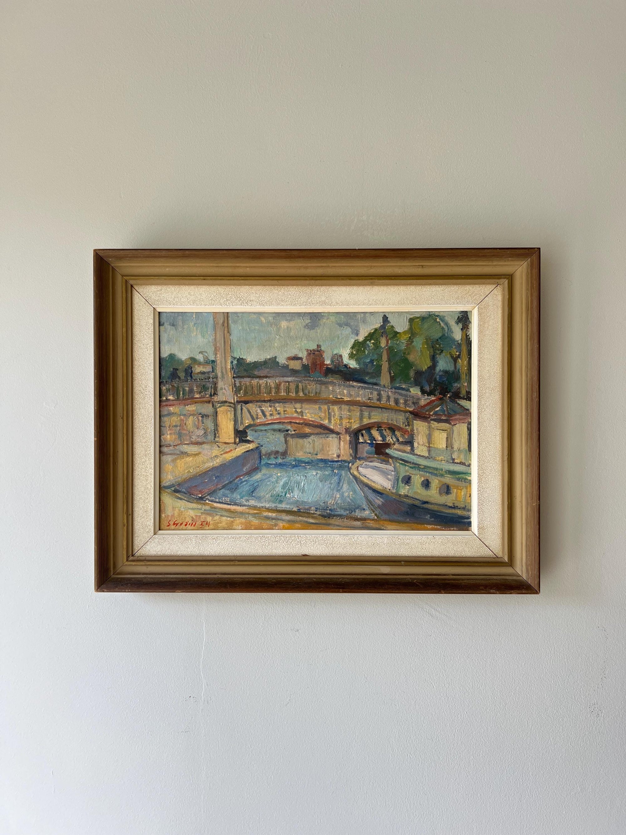 Framed vintage oil painting of a bridge over a river and a riverboat in a vintage frame, available at Hue.