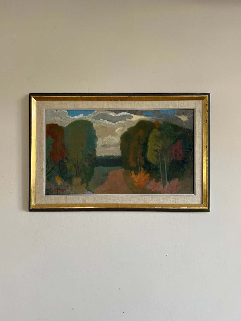 Framed painting of a landscape with autumnal trees and a vibrant sky and clouds, available from hue