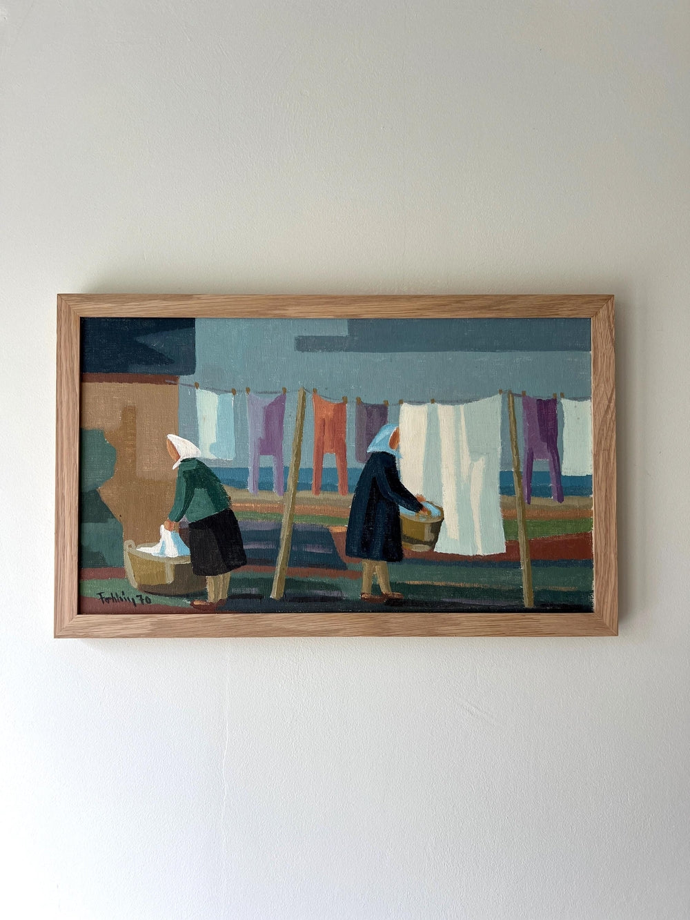 Framed artwork of two figures by a washing line in oak frame, available from hue