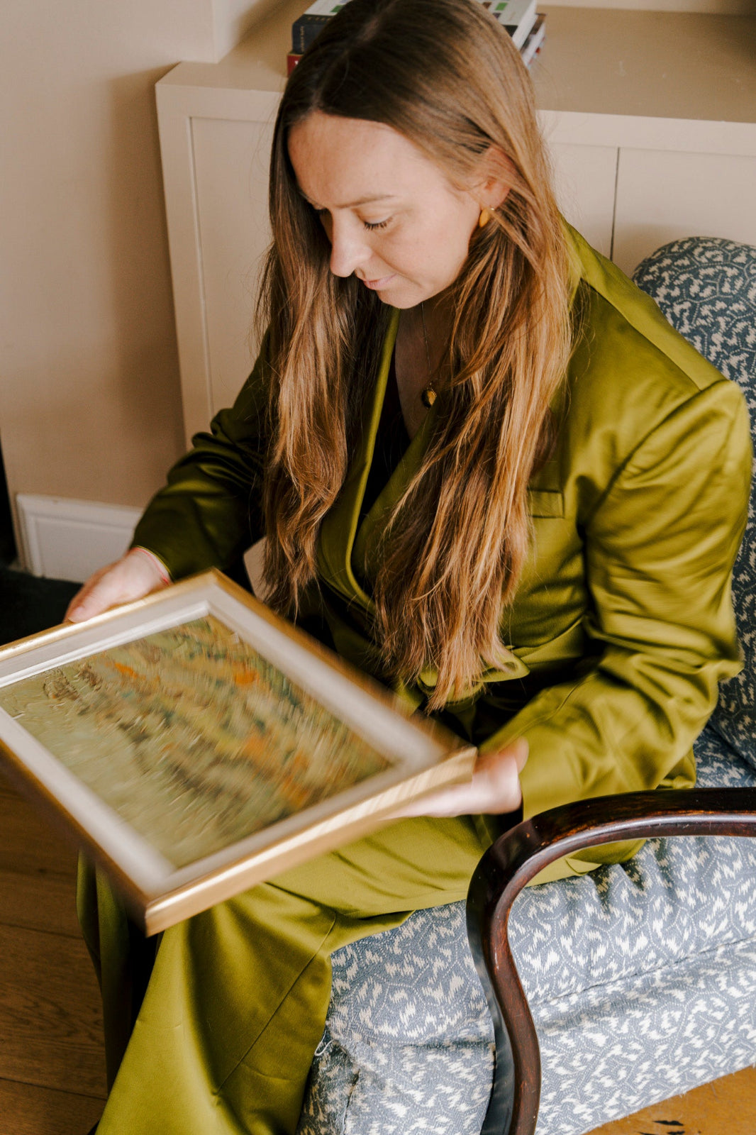 Vintage art curator examining an original French mid-century oil painting for the Hue and Holasz collection.