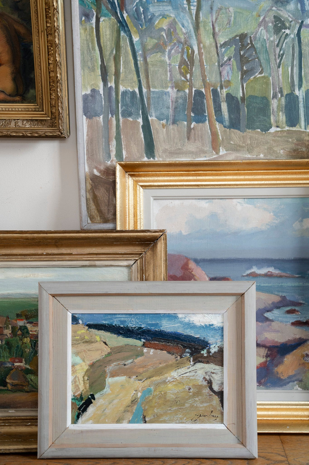 Original Scandinavian mid-century vintage art featuring framed landscape and coastal paintings in a curated collection.
