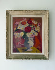 A framed vintage still life painting of a flower bouquet in a vasel. The artwork features a mix of red, white, yellow, and pink flowers with a blue-gray vase, enclosed in an ornate distressed silver frame. Available at Hue. 