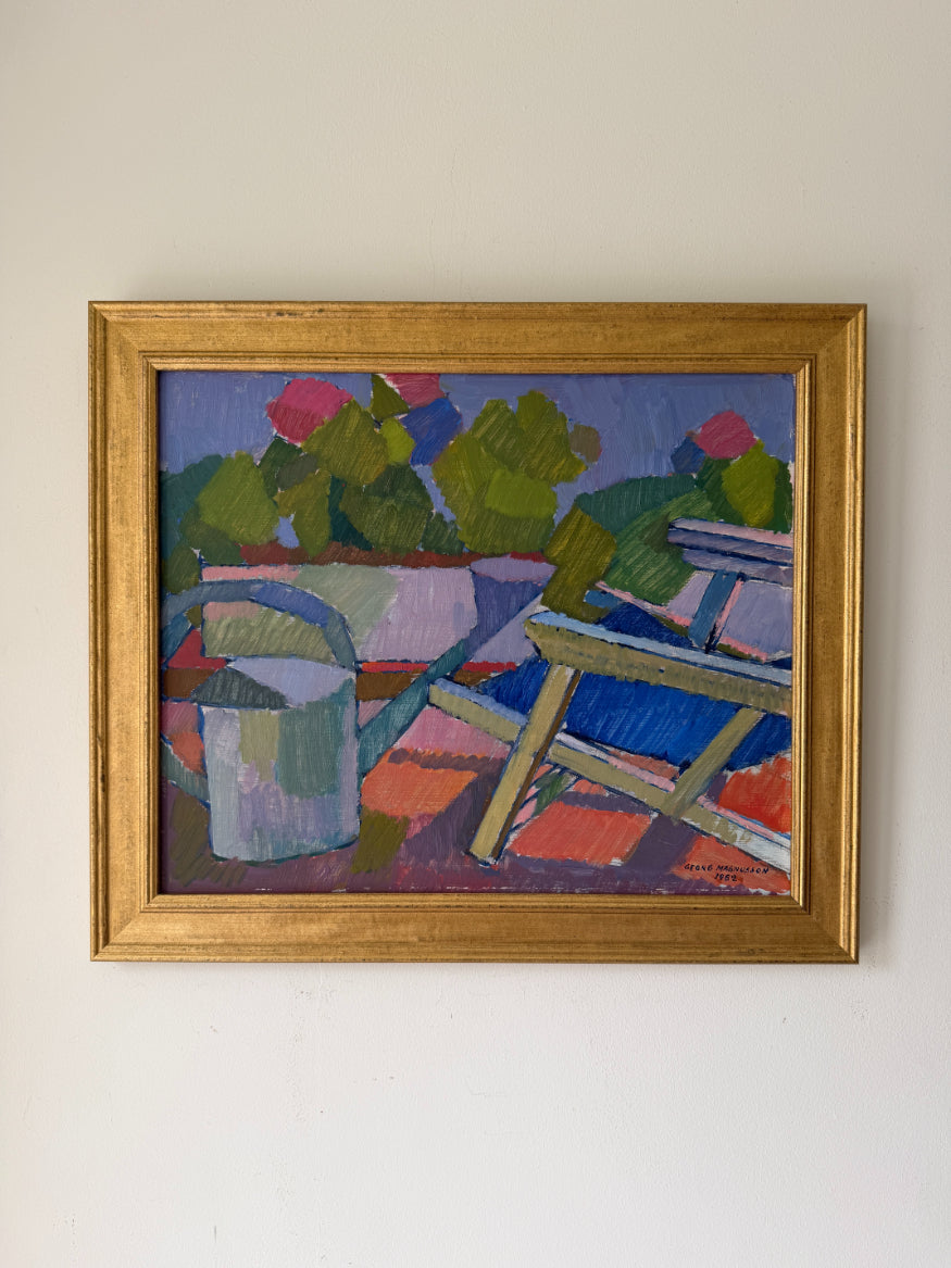 A framed vintage oil painting of a watering can and garden deckchair with pink florals. Available at Hue. 