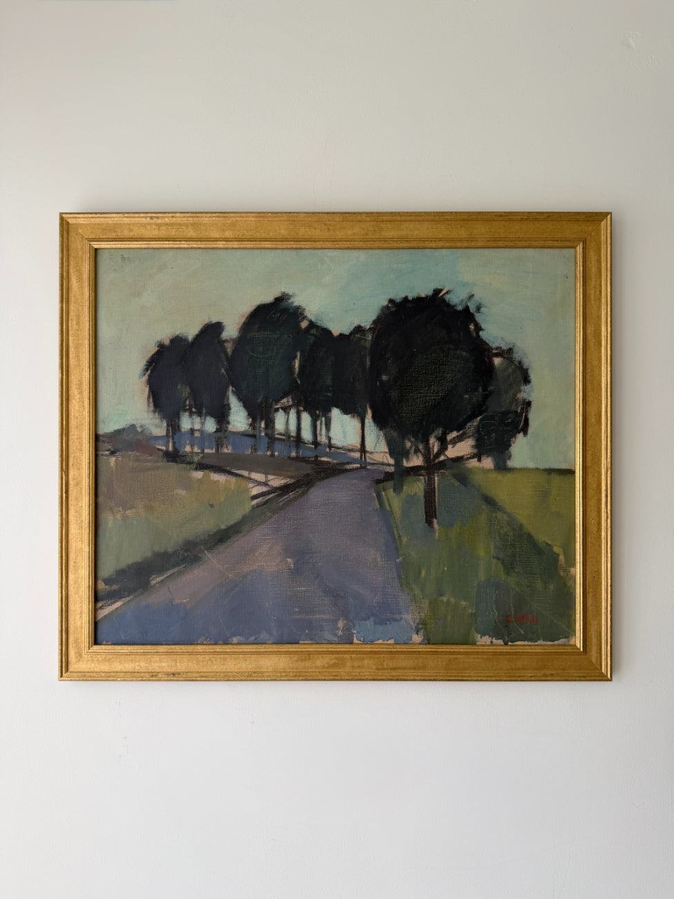 A framed vintage landscape oil painting depicting a road lined with dark trees under a pale sky. Available at Hue. 