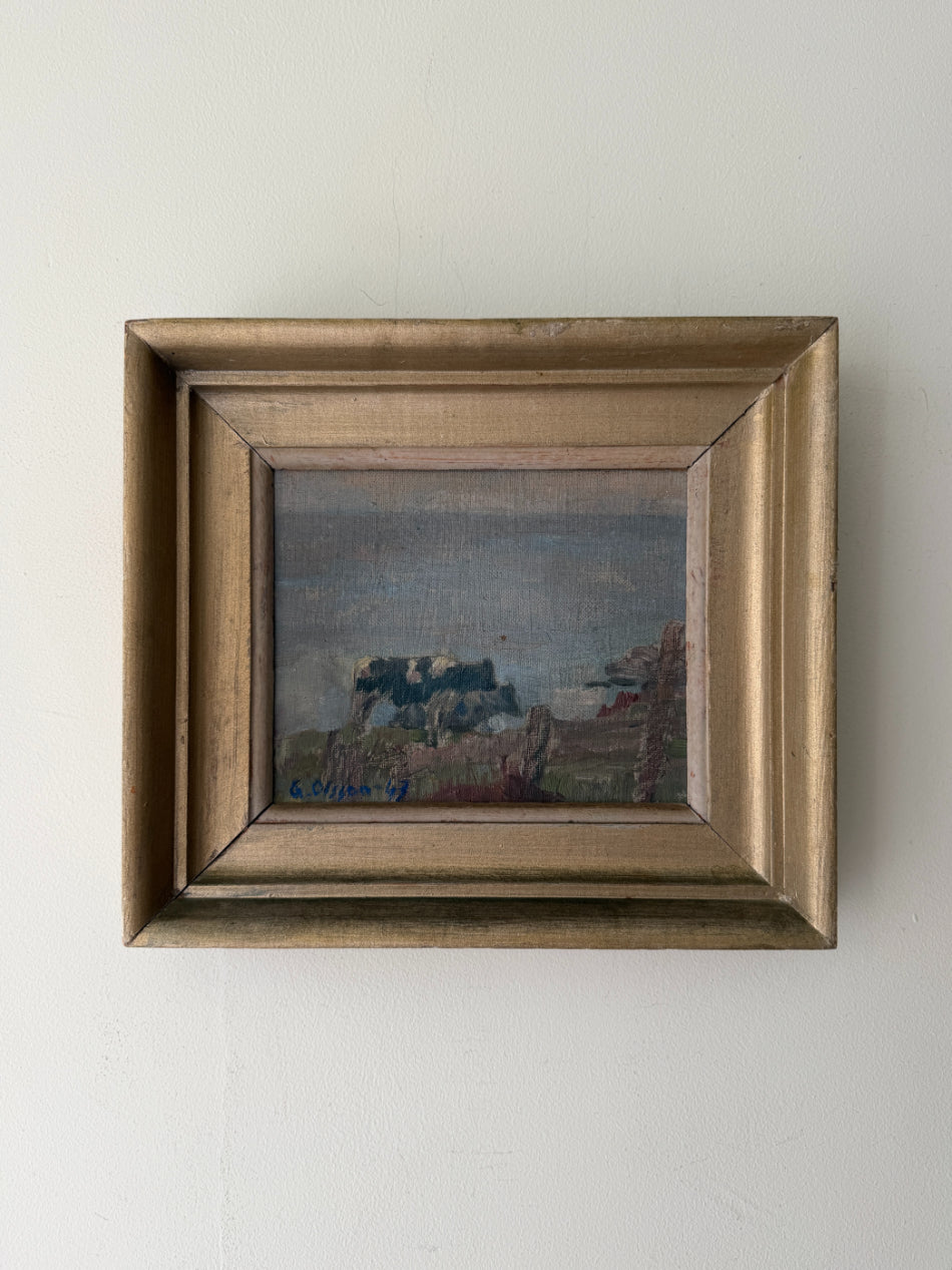 A small framed vintage landscape painting of grazing cows with a distressed gold frame. Available at Hue. 