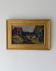 A framed vintage landscape painting featuring a small red-roofed house on a grassy hill, enclosed in a gold frame. Available at Hue. 