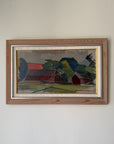 A framed vintage landscape oil painting of a rural scene with red barns, green trees, and a grey sky. Available at Hue.