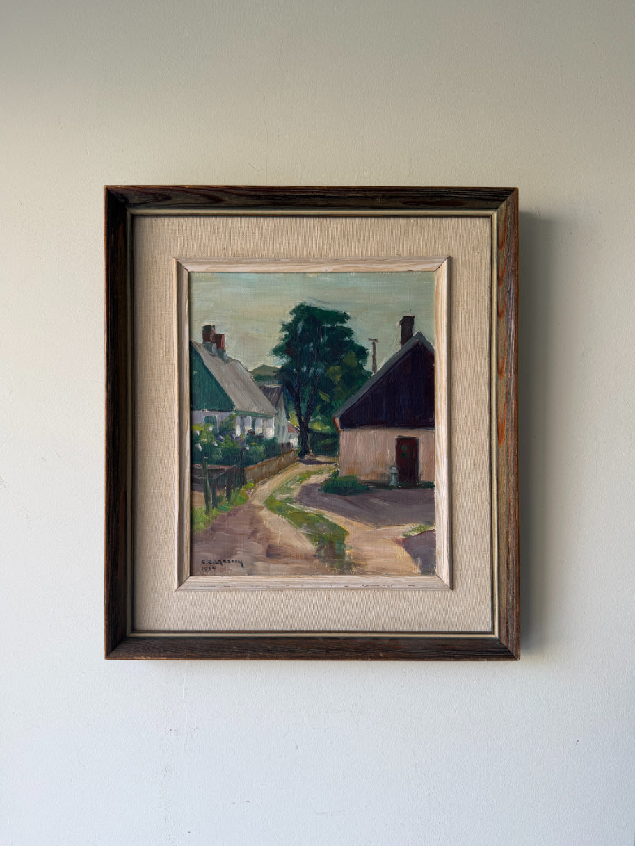 A framed vinatge landscape oil painting of a quiet village street with cottages and trees. Available at Hue. 