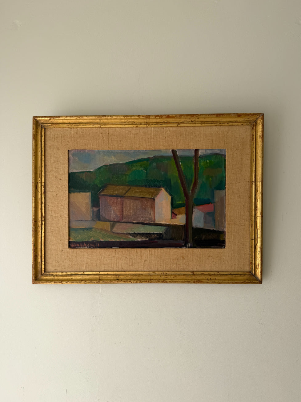 A framed vintage landscape painting featuring a stylized house, tree, and green hills. Available at Hue.