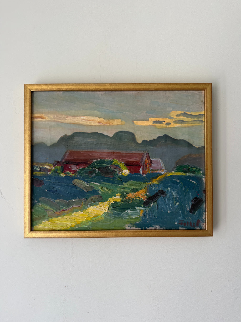 A framed vintage landscape oil painting. The painting depicts a red barn, green fields, and blue mountains under a cloudy sky, enclosed in a gold frame. Available at Hue.