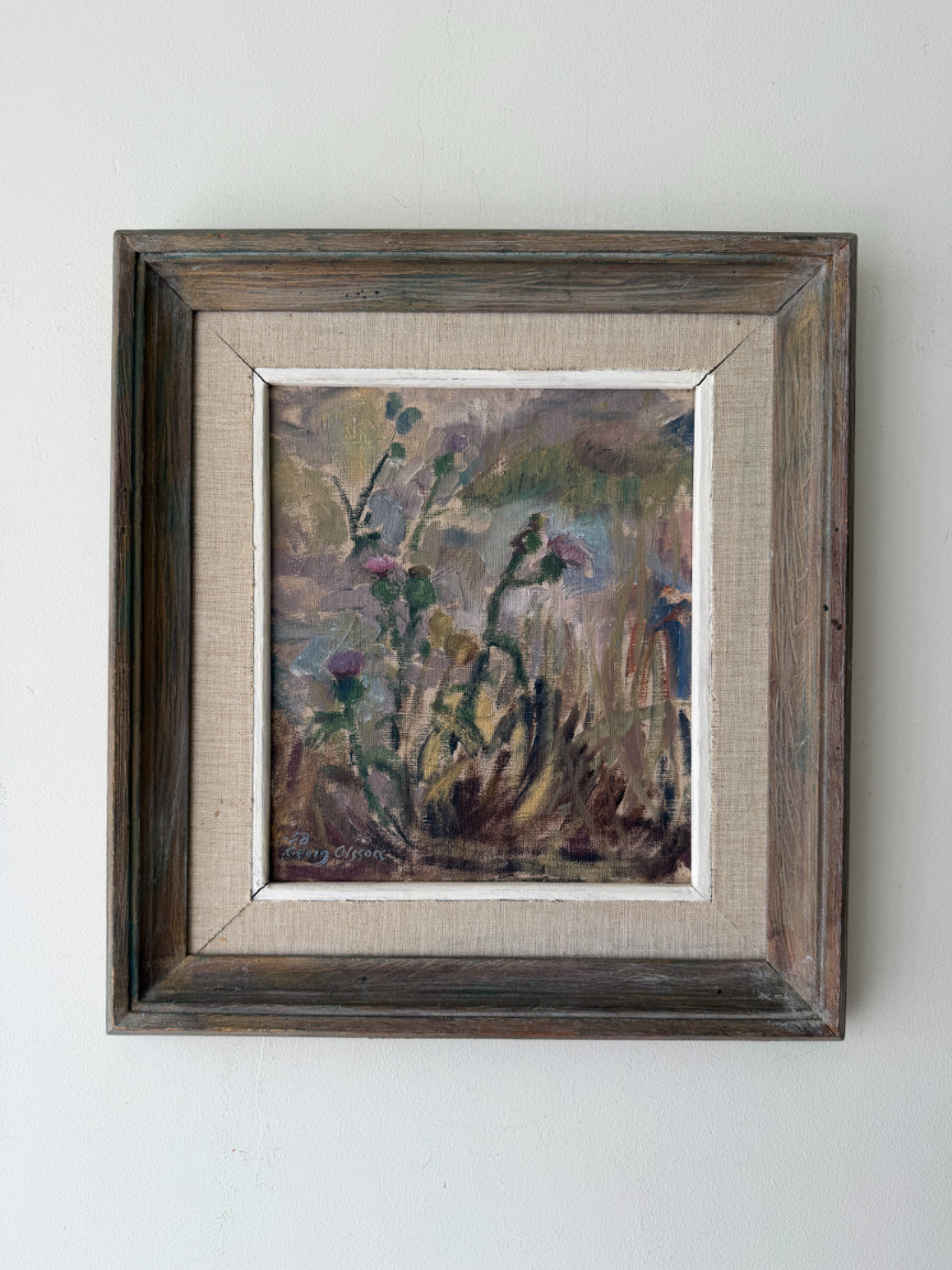 A framed vintage landscape oil painting featuring wildflowers, presented in a rustic dark brown wooden frame with a beige linen mat. Available at Hue. 