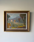 A framed vintage landscape oil painting  depicting a rural Italian-style scene with green fields, trees, hills, and a small house, enclosed in a rustic gold-toned wooden frame. Available at Hue. 