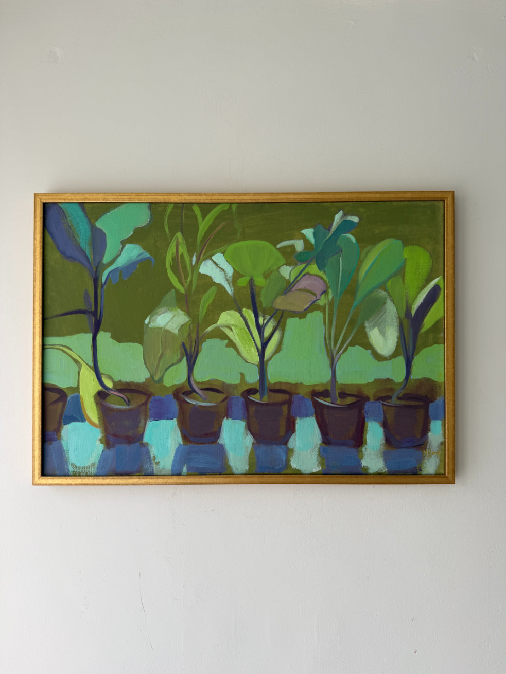 A framed vintage painting depicting a row of potted plants in shades of green, blue, and brown. Available at Hue. 
