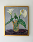 A framed vintage oil painting of white calla lilies in a clear glass vase on a dark surface, set against a muted gray background. Available at Hue. 