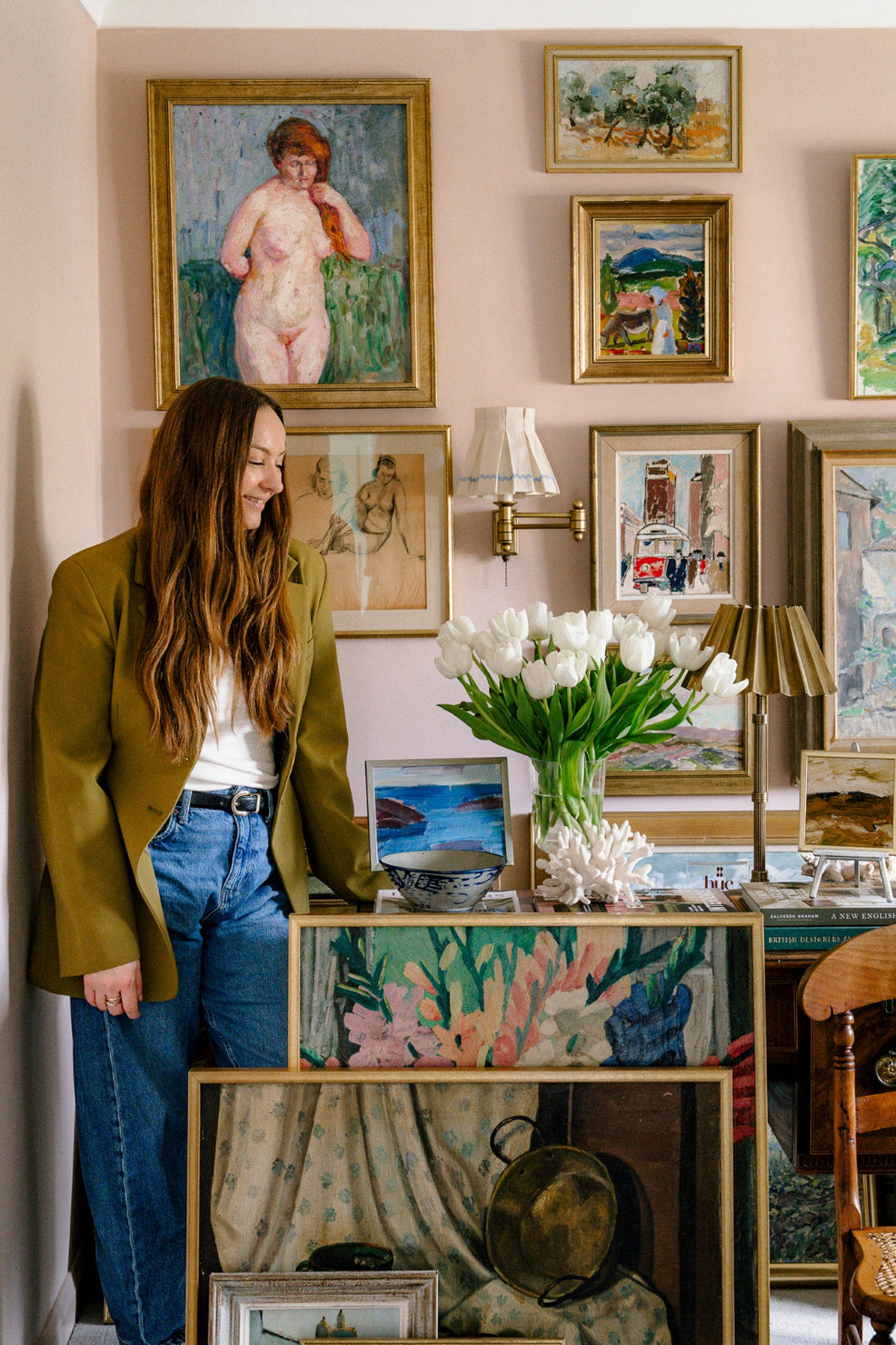 Curated collection of vintage art and original paintings displayed as a gallery wall, with framed artworks layered throughout a characterful collected interior by Hue + Holasz.